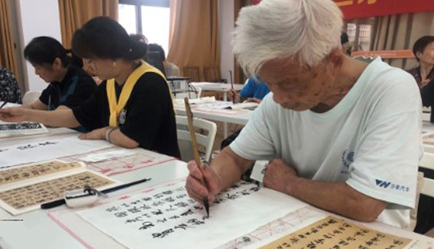 photograph showing seniors in calligraphy class